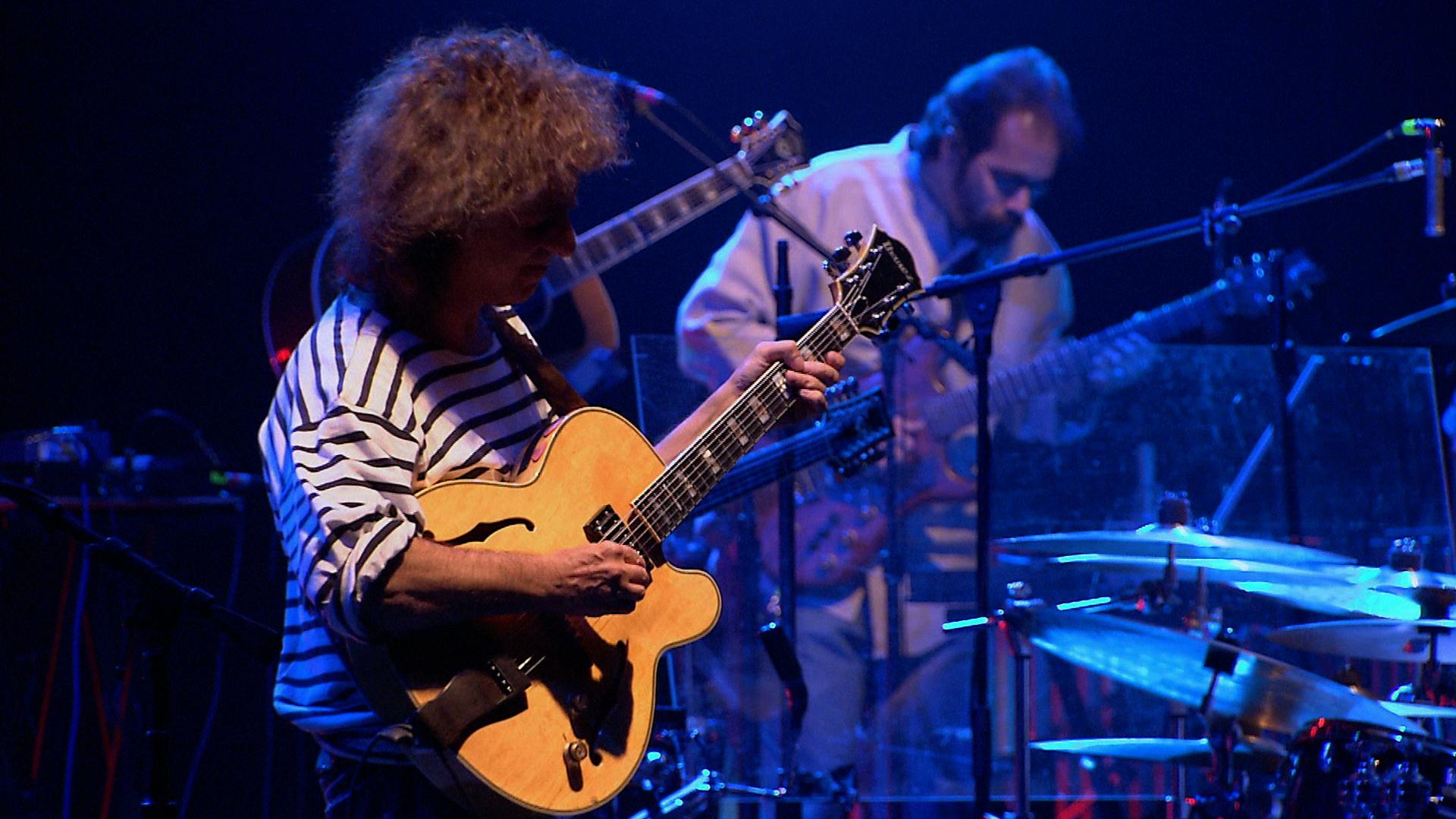 Pat Metheny playing guitar on stage.