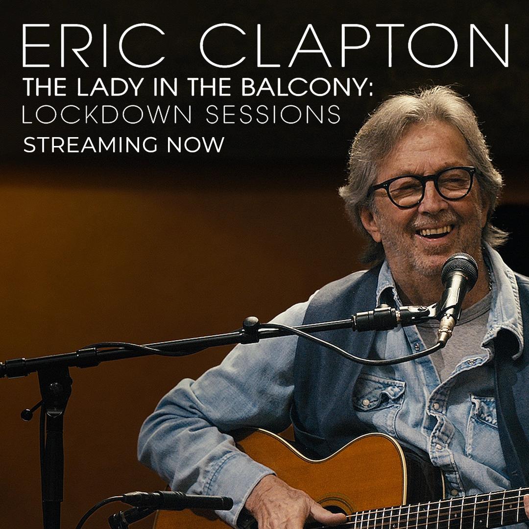 Eric Clapton sitting and playing guitar with a microphone, with text promoting "The Lady in the Balcony: Lockdown Sessions - Streaming Now.