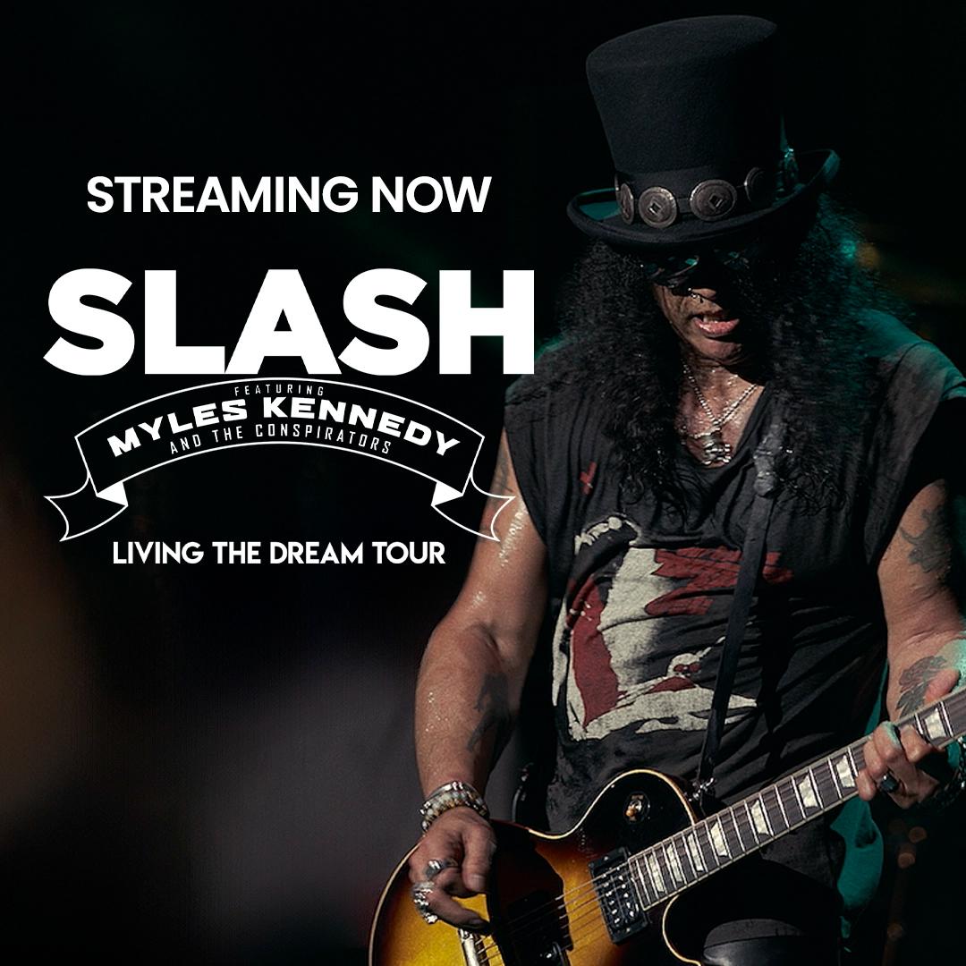 Promotional image for Slash's "Living the Dream Tour" featuring Myles Kennedy and the Conspirators. Text reads "STREAMING NOW". Slash is seen playing guitar, wearing his signature top hat and sunglasses.