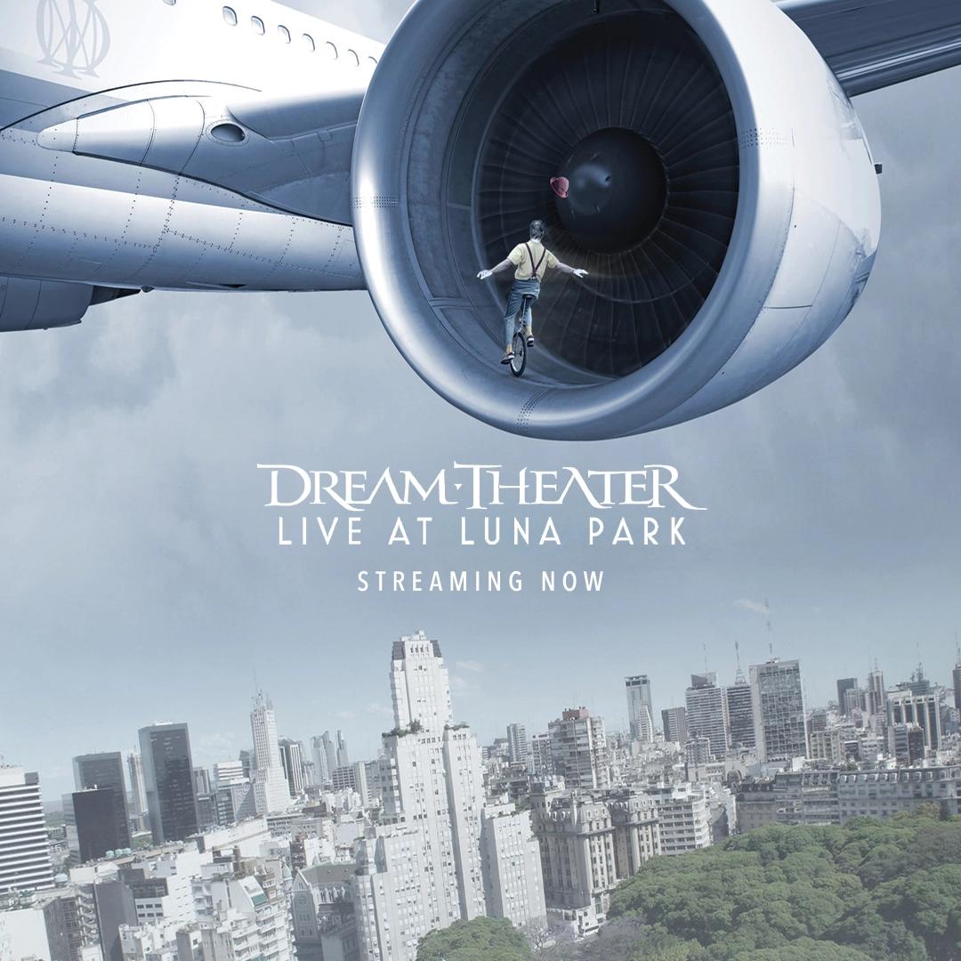 Person inside an airplane engine with the text "Dream Theater Live at Luna Park Streaming Now" superimposed on the image. The background shows a cityscape with tall buildings and a park.