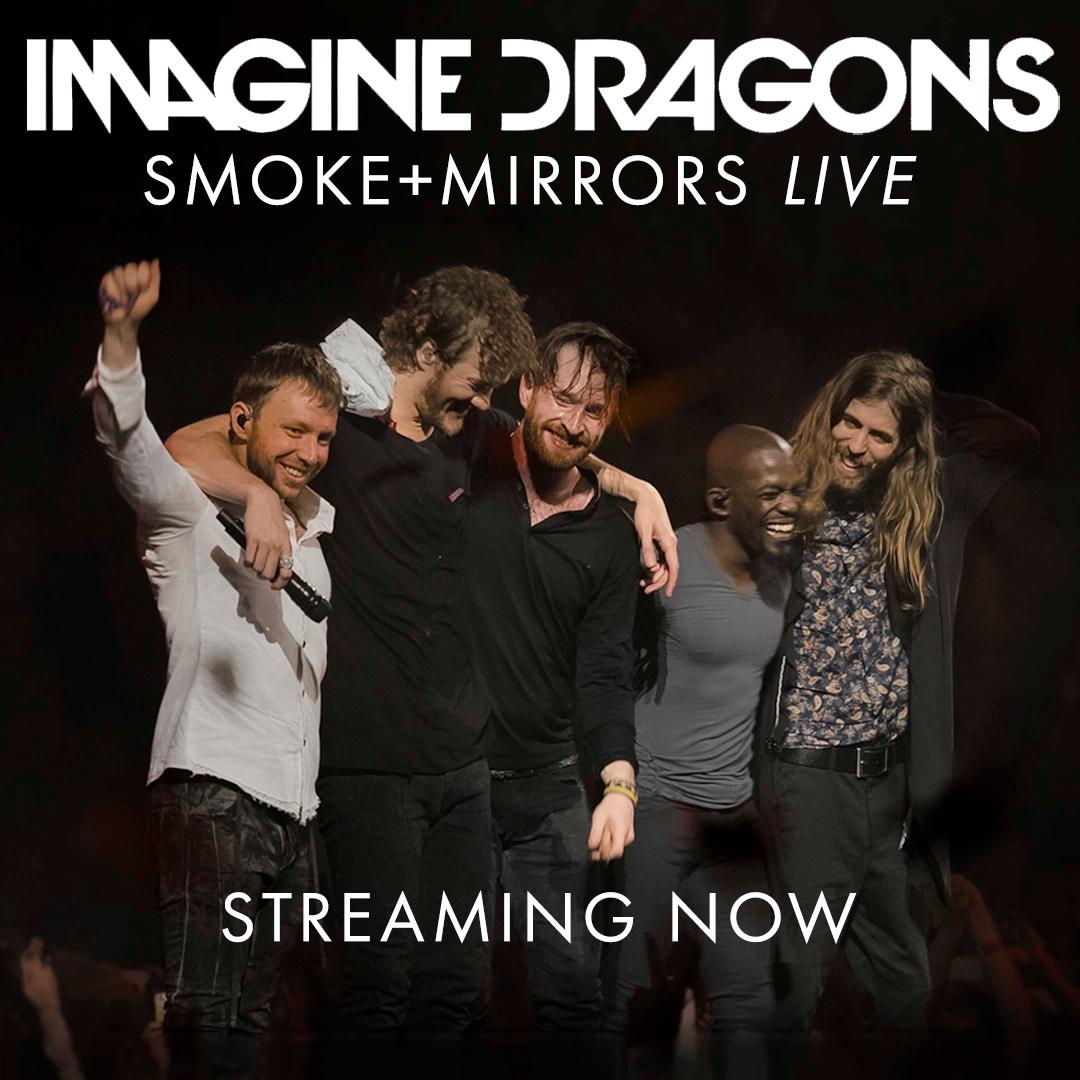 Five band members of Imagine Dragons standing together with arms around each other, promoting their “Smoke + Mirrors Live” album with the text “Streaming Now.”.