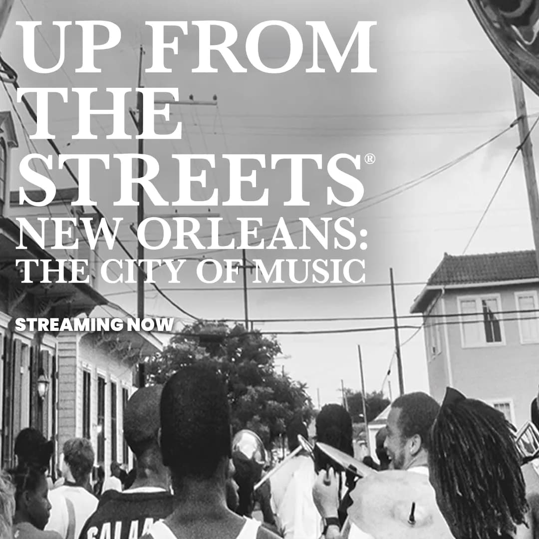 A crowd of people walking on a city street, with the text "Up From the Streets: New Orleans - The City of Music, Streaming Now" overlayed in large white font.