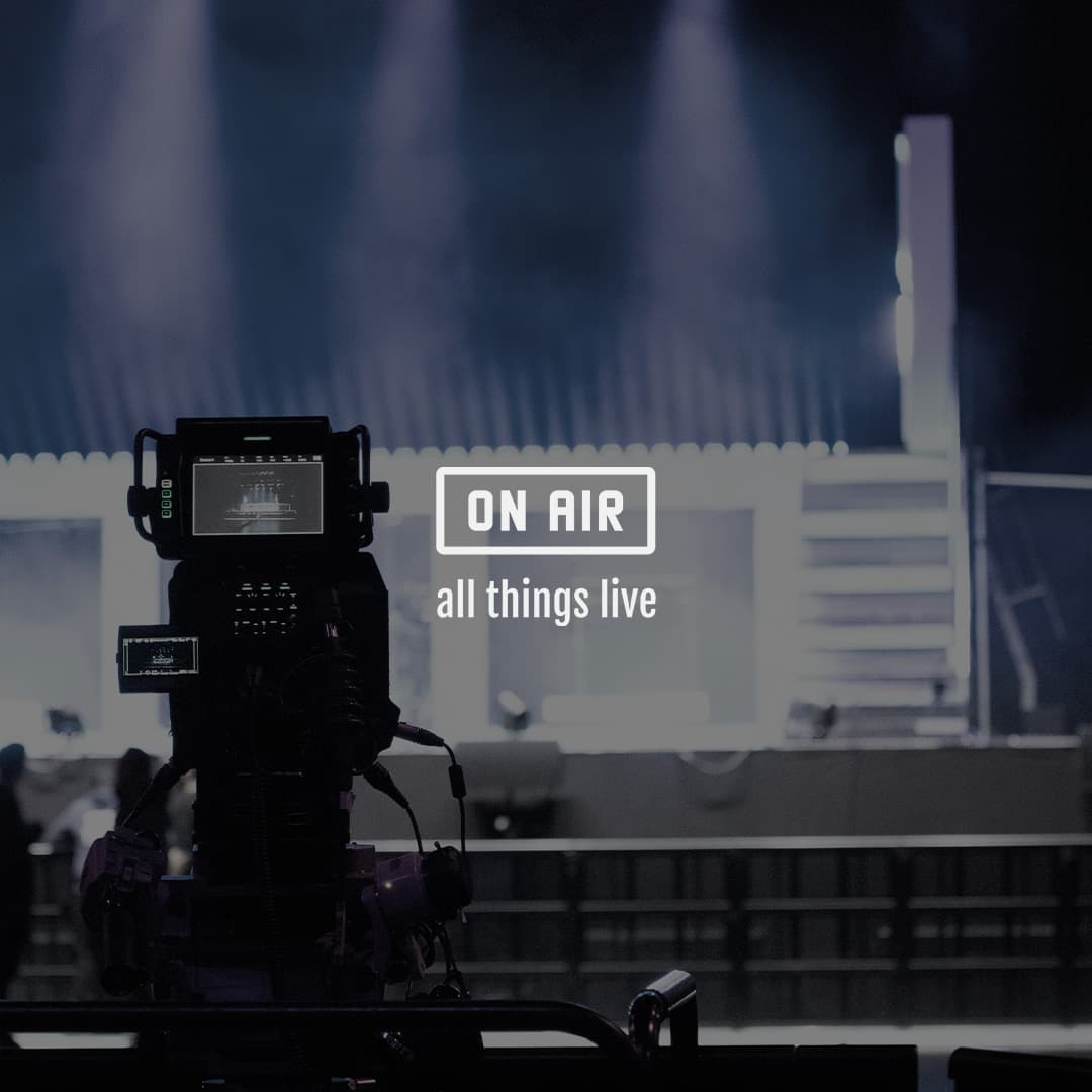 A video camera is set up in front of a blurred stage with the text "ON AIR all things live" overlaid.