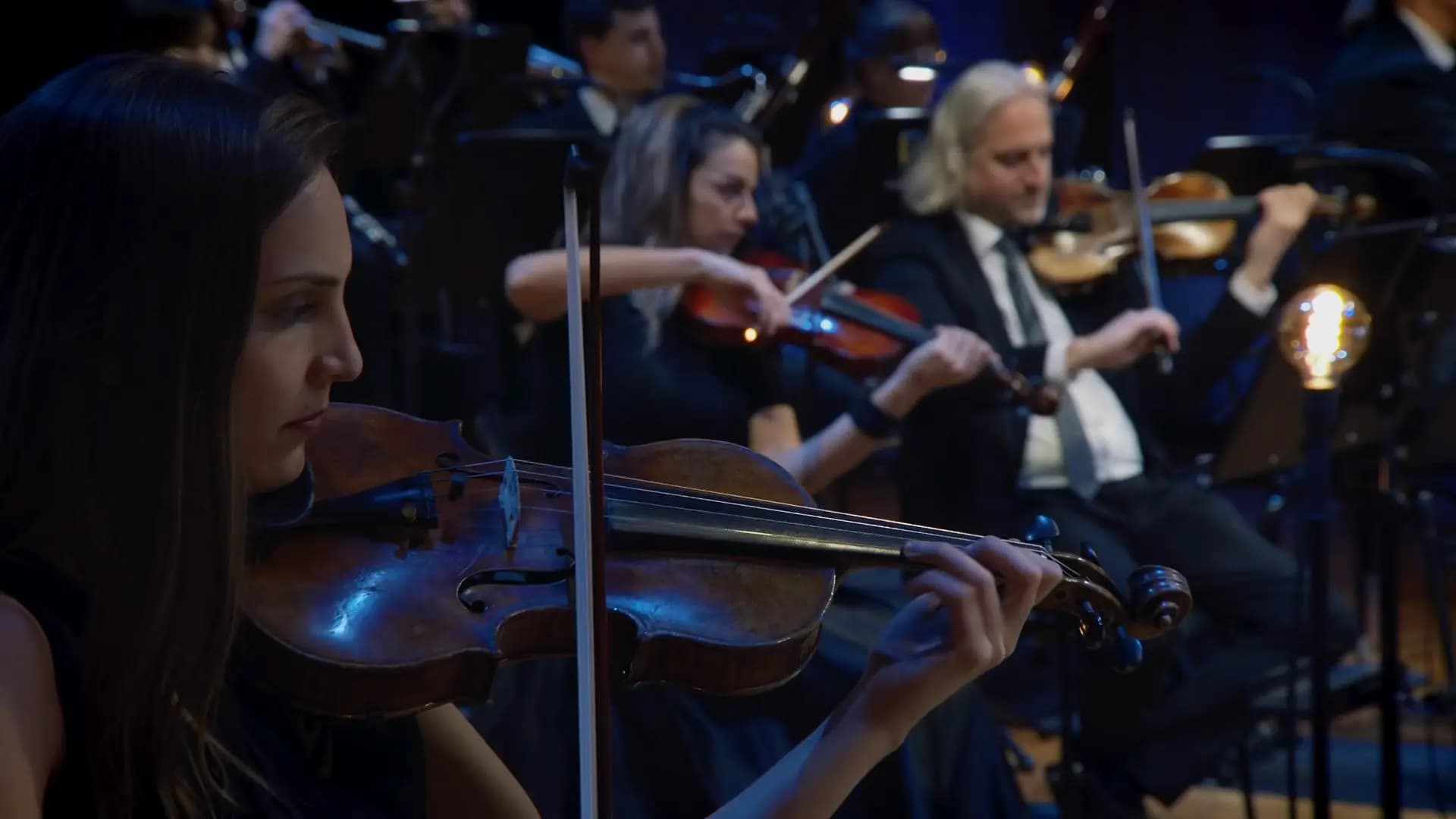 the string section of the Synchron Stage Orchestra as they perfrorm with conductor Johannes Vogel