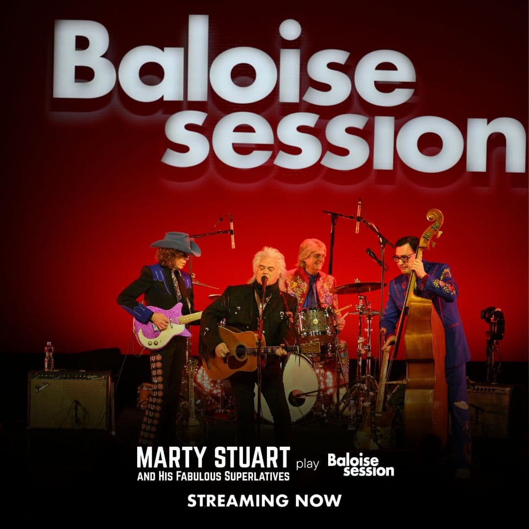 Marty Stuart and His Fabulous Superlatives perform on stage with instruments under the "Baloise session" sign, promoting their streaming concert.