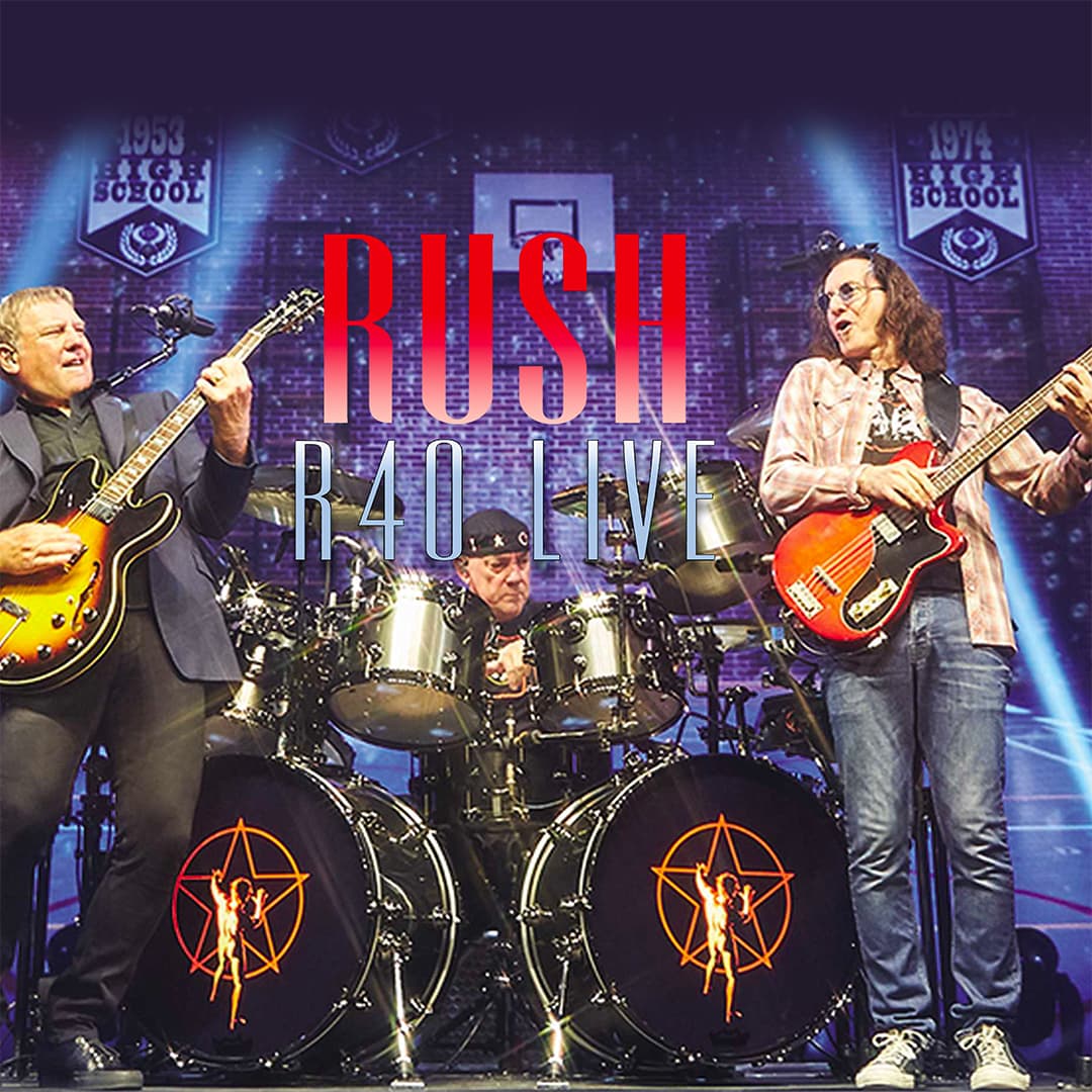Three musicians from the band Rush perform live on stage with guitars and drums, beneath a large "RUSH R40 LIVE" banner and backdrop featuring high school banners.
