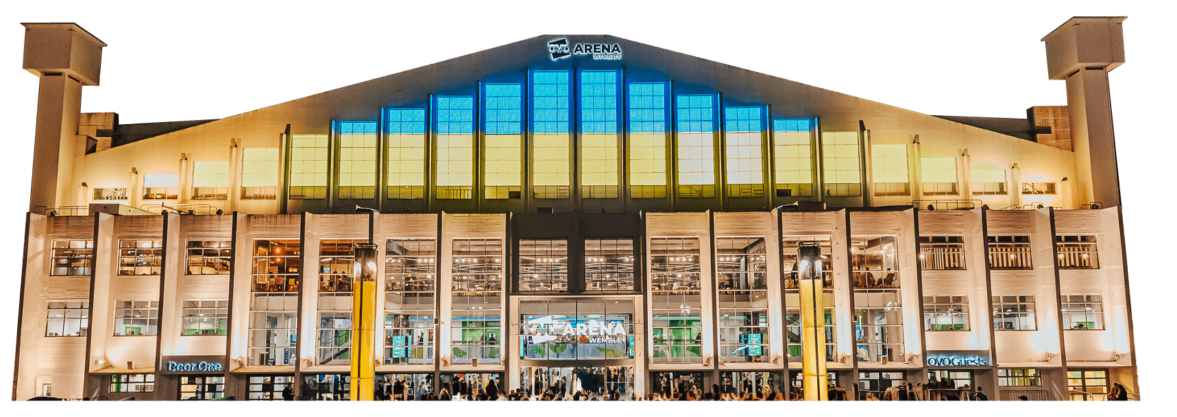 Exterior view of OVO Arena Wembley at night, featuring a large facade with multiple windows and a prominent entrance below.