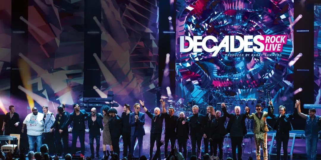 Chicago stands on stage holding hands in front of a vibrant "Decades Rock Live" backdrop.