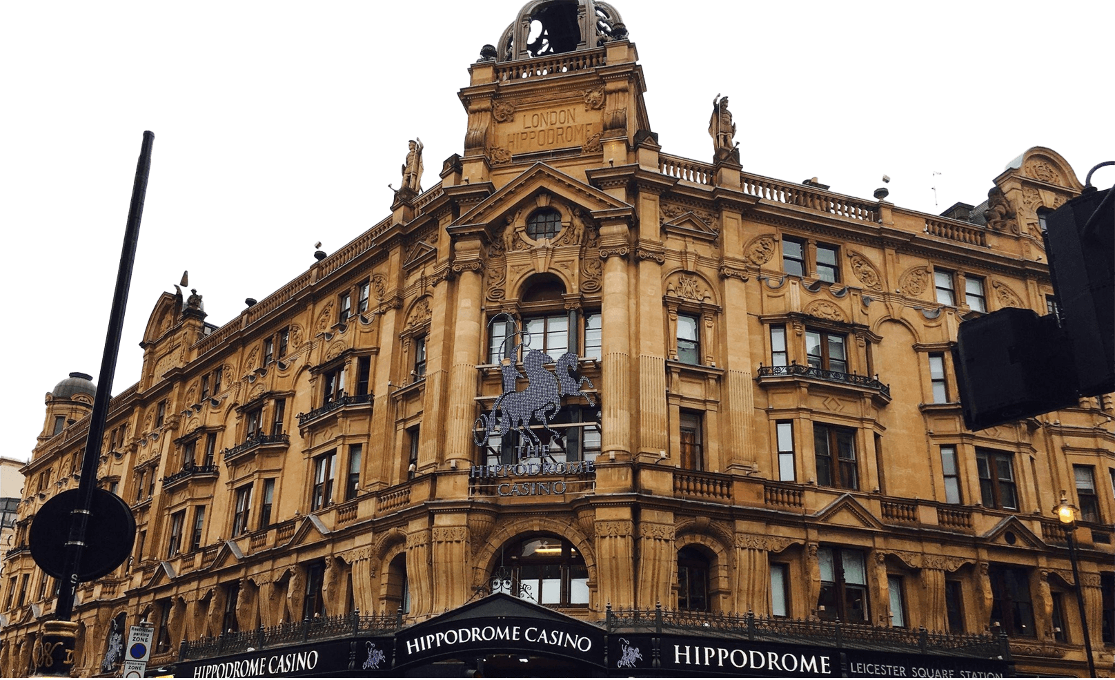 A grand historic building with ornate architecture houses the Hippodrome Casino in London; its facade features columns, statues, and signage.