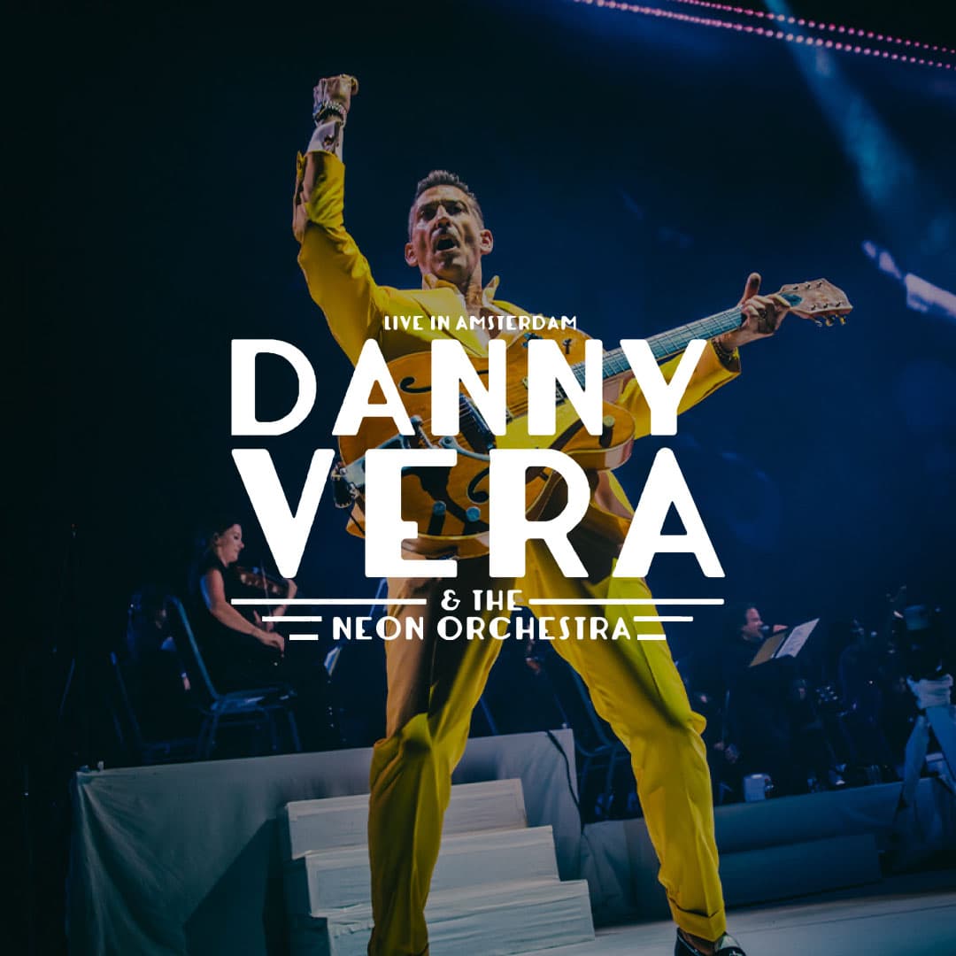 Danny Vera in a yellow suit plays guitar on stage with an orchestra in the background. Text reads: "Live in Amsterdam Danny Vera & The Neon Orchestra.