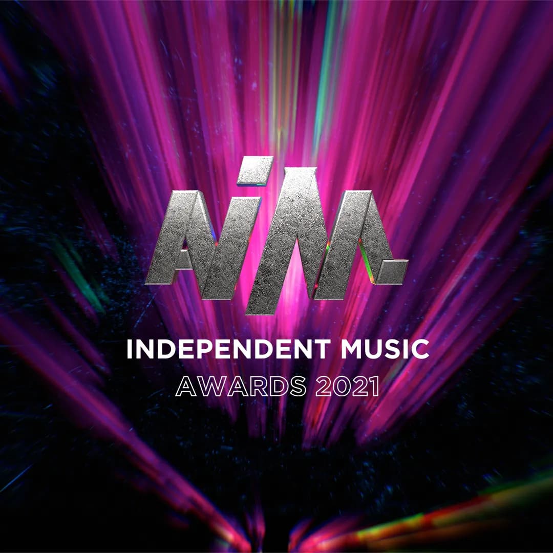 Logo for the AIM Independent Music Awards 2021, featuring metallic text against a vibrant purple and black streaked background.