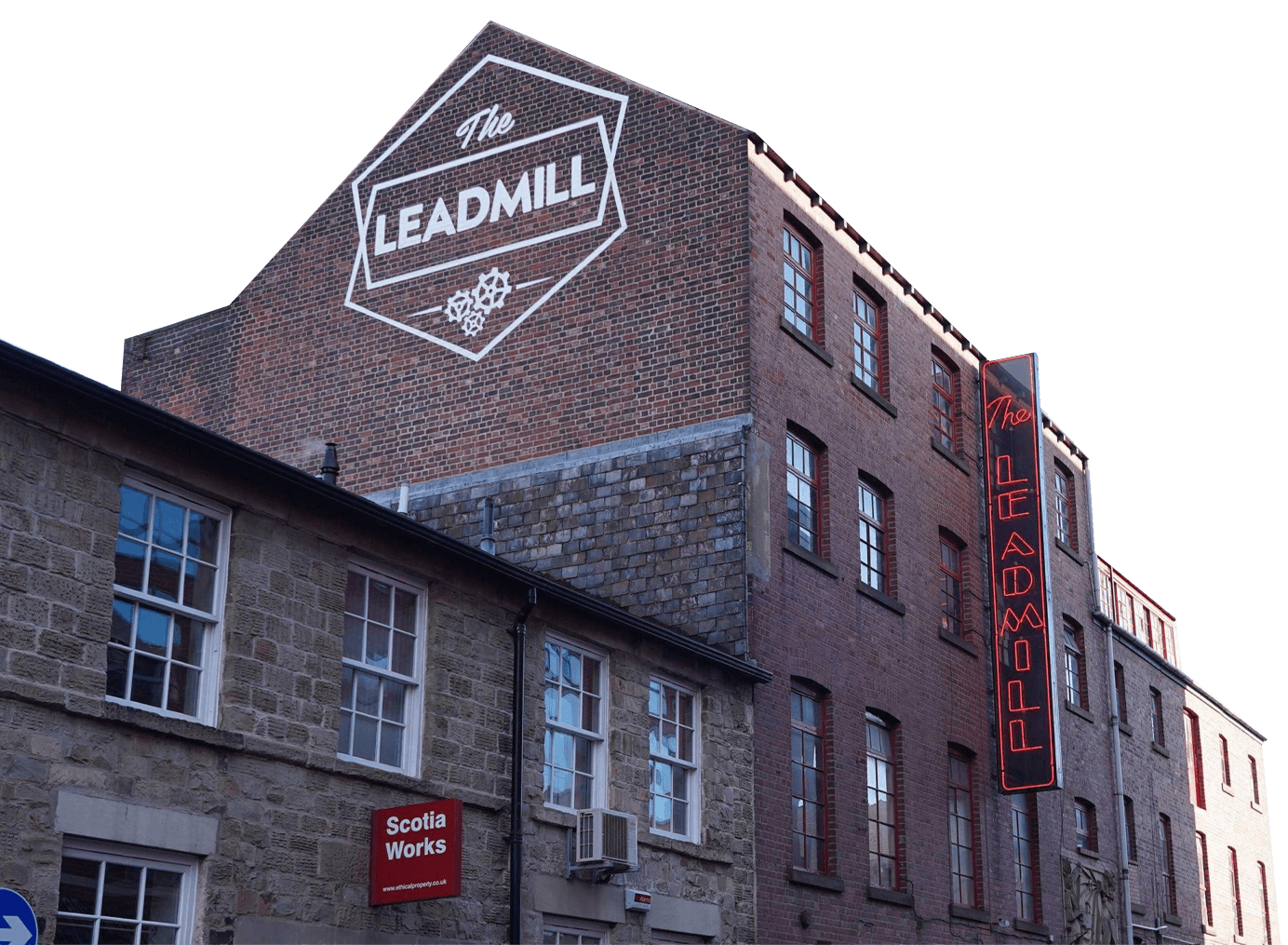 A red-brick building with a large painted sign reading "The Leadmill" and a vertical neon sign on the side, next to another building labeled "Scotia Works.