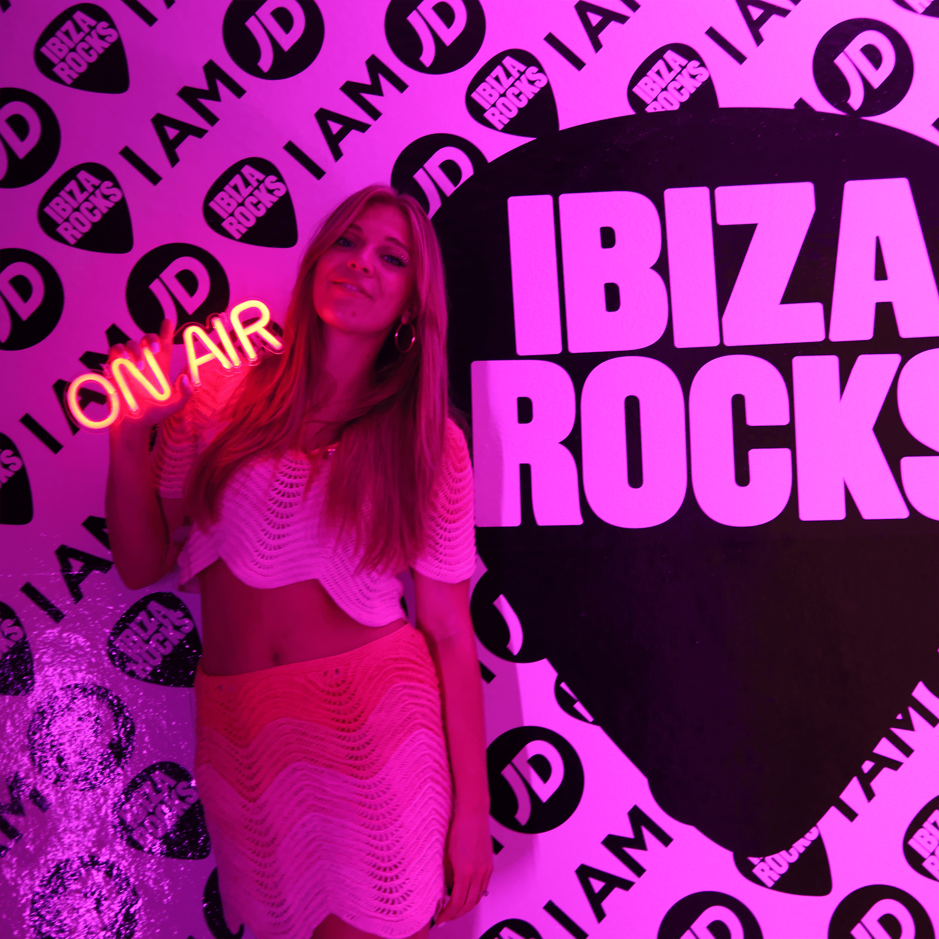 Becky Hill holding an On Air neon sign